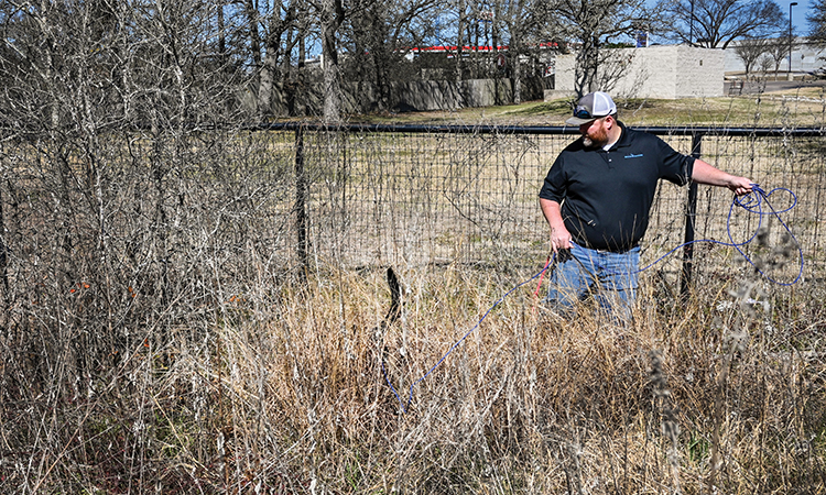 It's a typical workday, and Charlie is up to his tail in tall grass, left, as he sniffs for water leaks along Union Chapel Road in Cedar Creek with his handler, Clifton Smith. The pair work for Aqua Water Supply Corp., which serves residents and businesses in a 1,065-square-mile area in six Texas counties, including most of Bastrop County and parts of Travis, Lee, Caldwell, Fayette and Williamson counties.