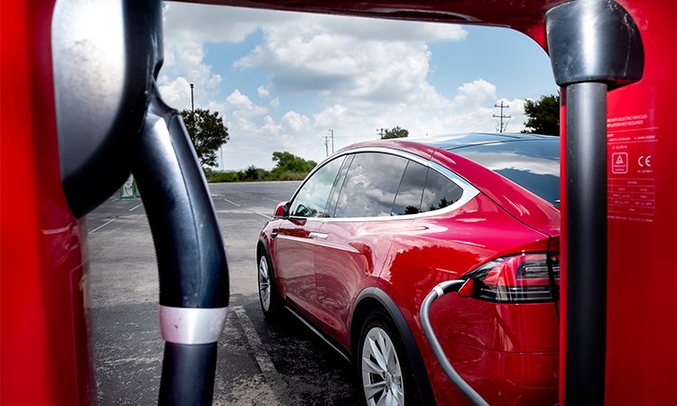 A Tesla charges at one of a dozen Tesla Supercharger stations at the San Marcos Premium Outlet mall along Interstate 35. The area also has EVgo and ChargePoint stations, which are both DC fast chargers for other types of electric vehicles. (Laura Skelding photo)