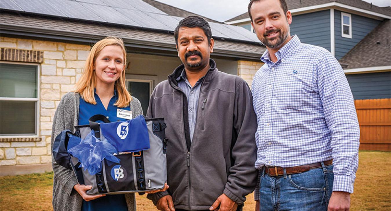 Brittany Hardy, Bluebonnet Electric Cooperative member service representative (left), Bluebonnet memember Pandiyan Kaliyamoorthy of Austin (center), and Wesley Brinkmeyer, Bluebonnet's manager of energy services. (Sarah Beal photo)