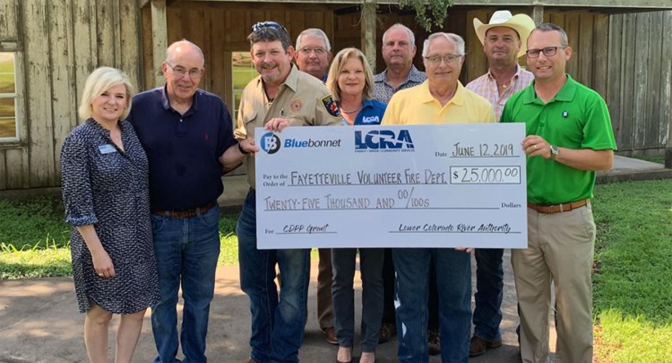 LCRA and Bluebonnet Electric Cooperative representatives present a $25,000 grant to the Fayetteville Volunteer Fire Department for a new emergency helipad.