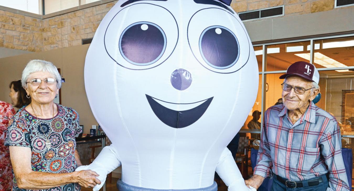 JoAnn and Antone Schrader of Caldwell meet Bluebonnet’s new mascot at the Giddings member service center during one of five 80th birthday parties across the service area. Sarah Beal photo 