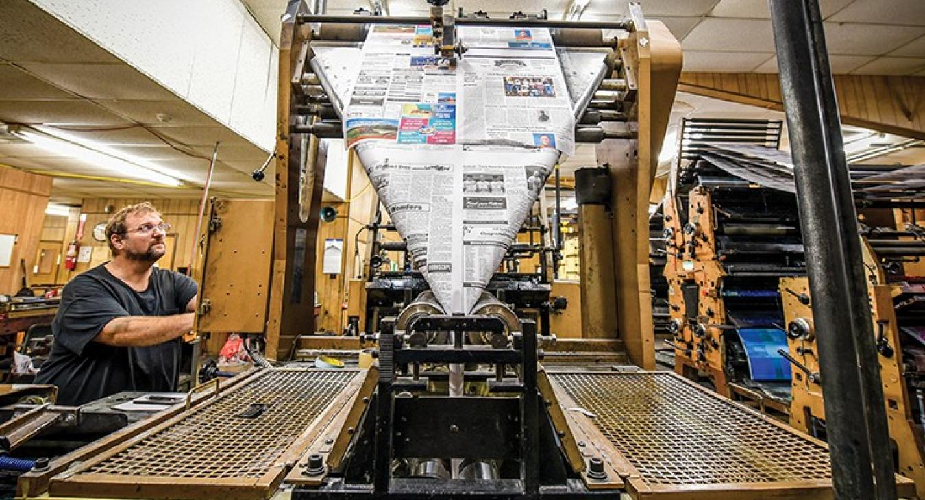 Printing supervisor Clifton Green, who has been at the Brenham Banner Press for more than 30 year, check the calibration of the printing press