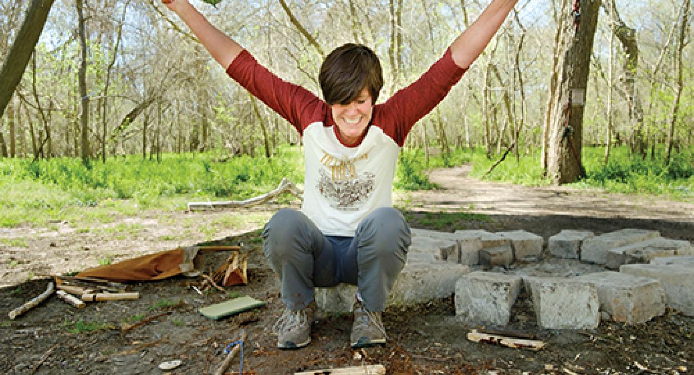 Writer Pam LeBlanc celebrates her mastery of the elements after starting a fire in the wilderness.