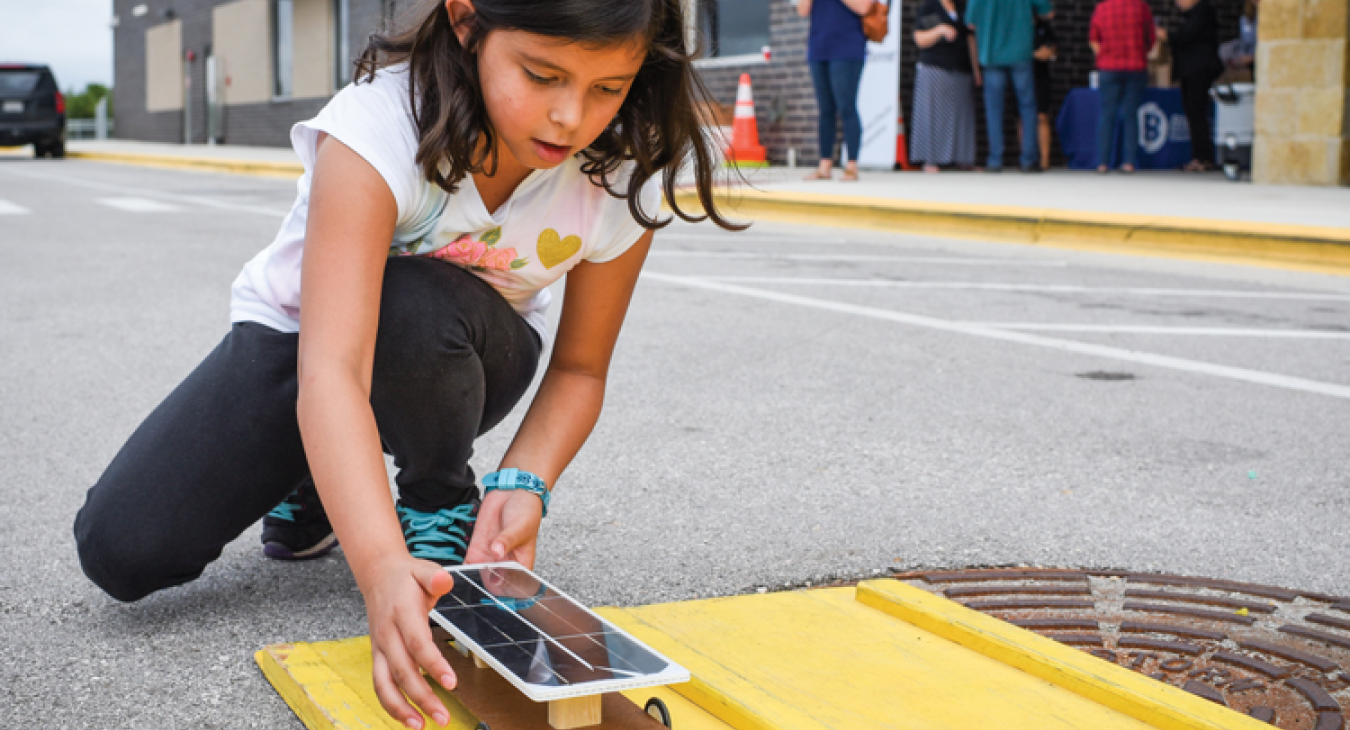 Gabriella Villebrun, 8, of Dale, launches a solar-powered car she assembled at the kid-friendly event.