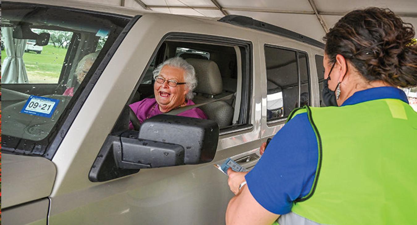 Angela Coy, manager of accounts receivable at Bluebonnet, assists in registering member Linda Makowsky of Burton during the cooperative’s drive-through Annual Meeting at the Silos on 77 near Giddings on May 11, 2021. (Sarah Beal photo)